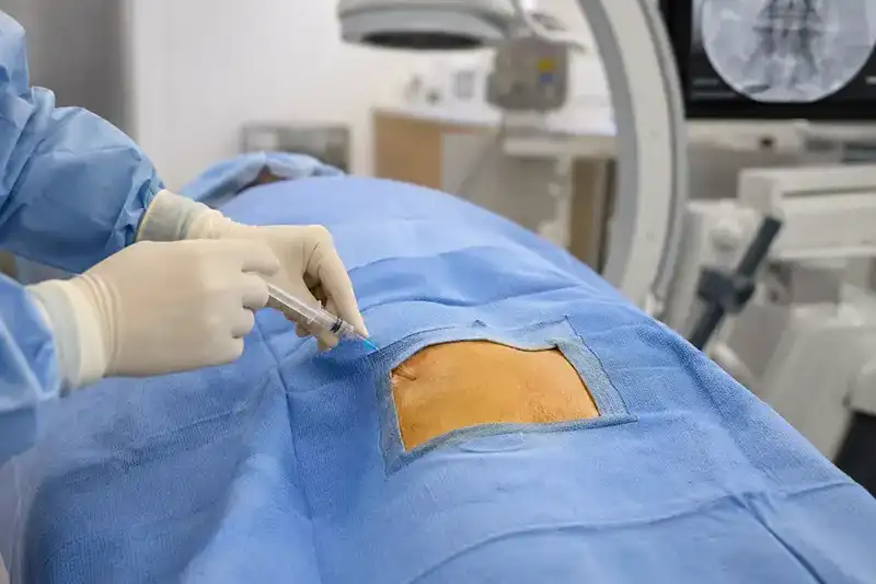 A physician pointing to the facet joints on a detailed lumbar spine anatomical model, illustrating the precise spinal structures targeted during facet joint injections at Shore Spine & Pain.