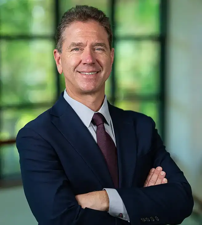Dr. Woska headshot with arms crossed smiling