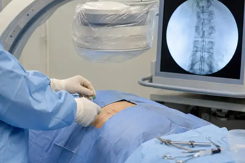 A smiling clinician reviewing information at a computer workstation during a patient consultation, reflecting the personalized care approach to peripheral nerve stimulation at Shore Spine & Pain.